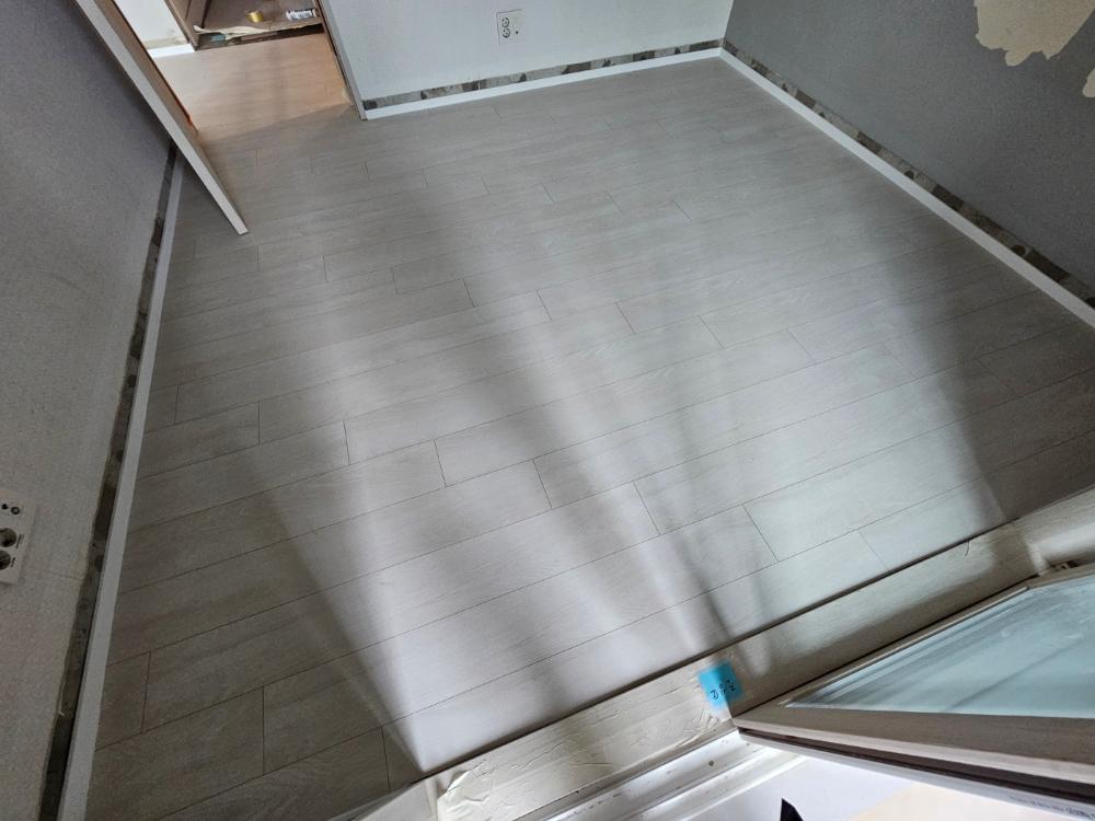 회색 바닥재와 도배지가 제거된 벽면