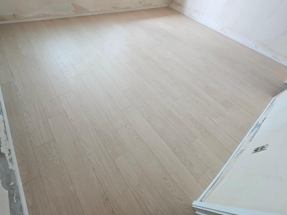 흰색 벽면과 목재 바닥재로 마감된 빈 방