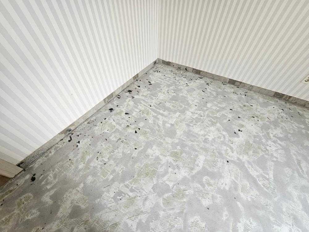 줄무늬 벽지와 마감재가 벗겨진 방 모서리