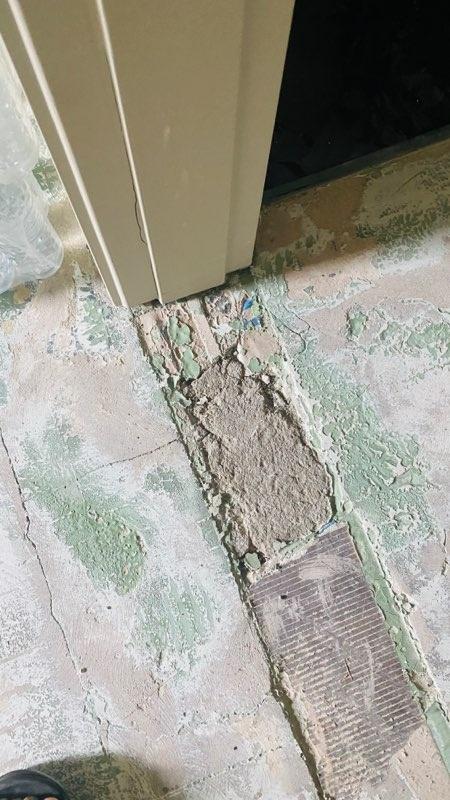 타일이 제거되어 흙과 먼지가 쌓인 바닥면