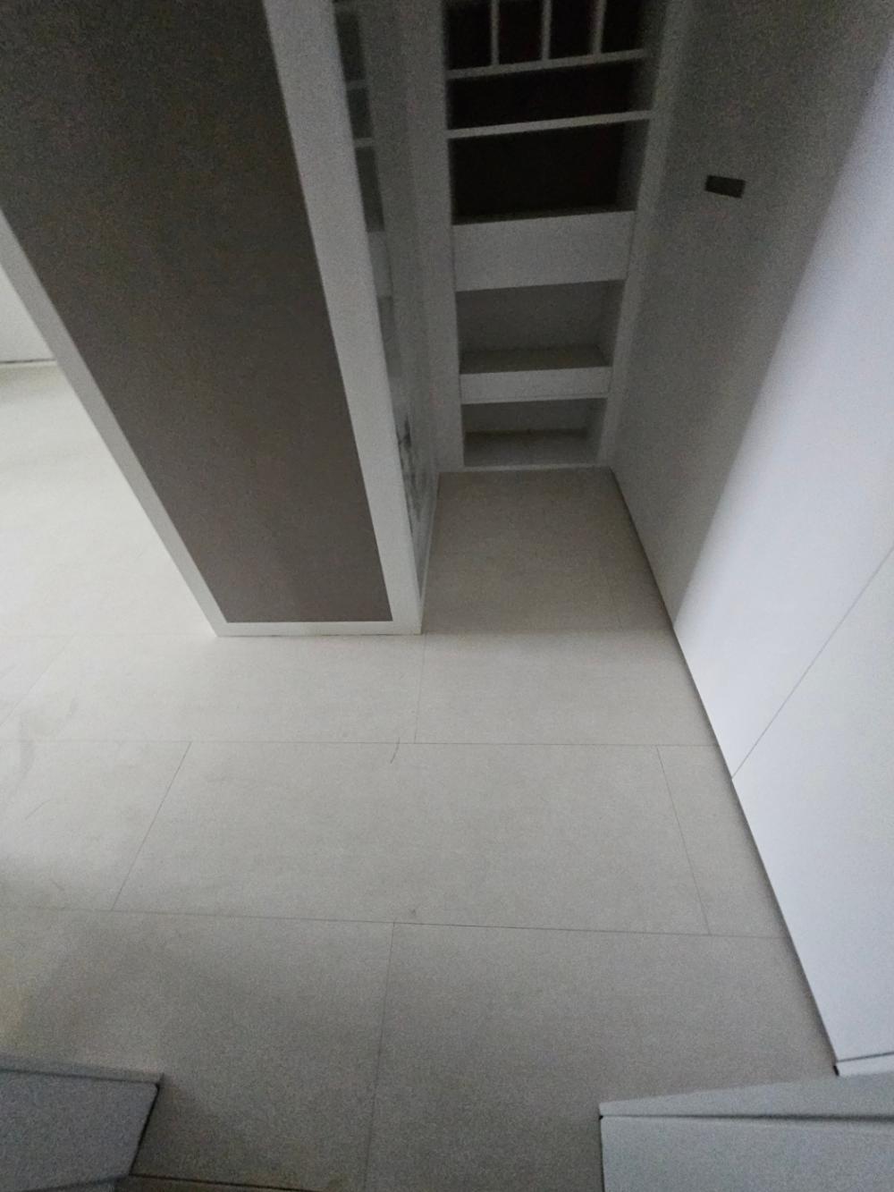 회색 벽면과 수납장이 설치된 복도 구간