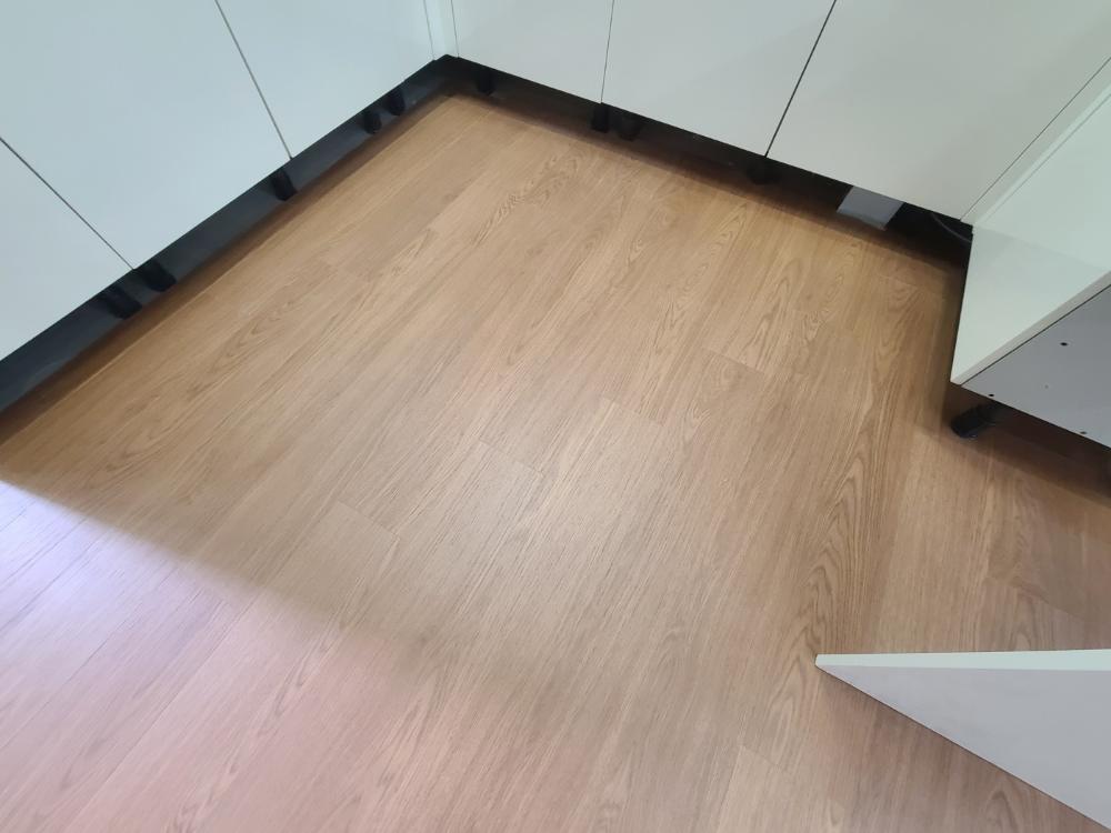 흰색 벽면과 나무 패턴 바닥의 접합부