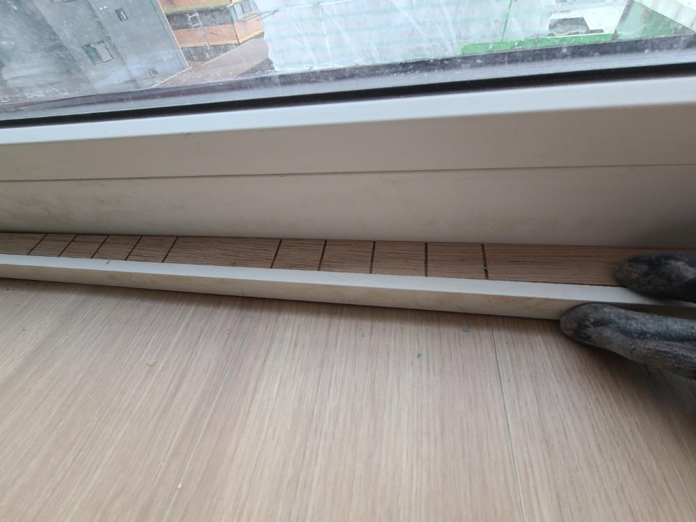 창호 프레임과 바닥재가 만나는 하단 베이스보드 근접 샷