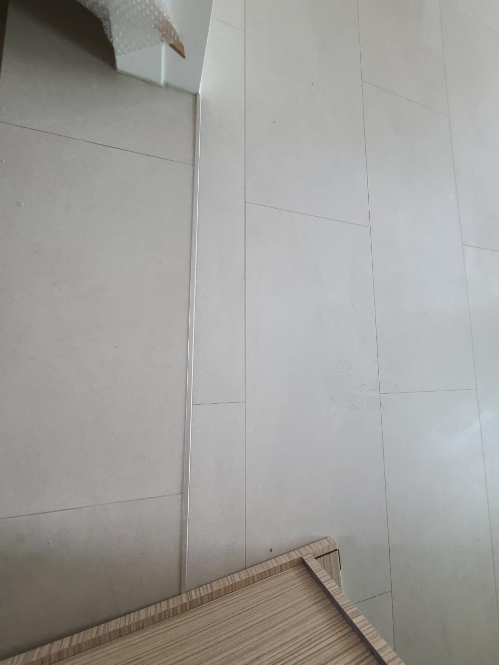 베이지색 벽면과 타일 벽면이 만나는 접합부 디테일