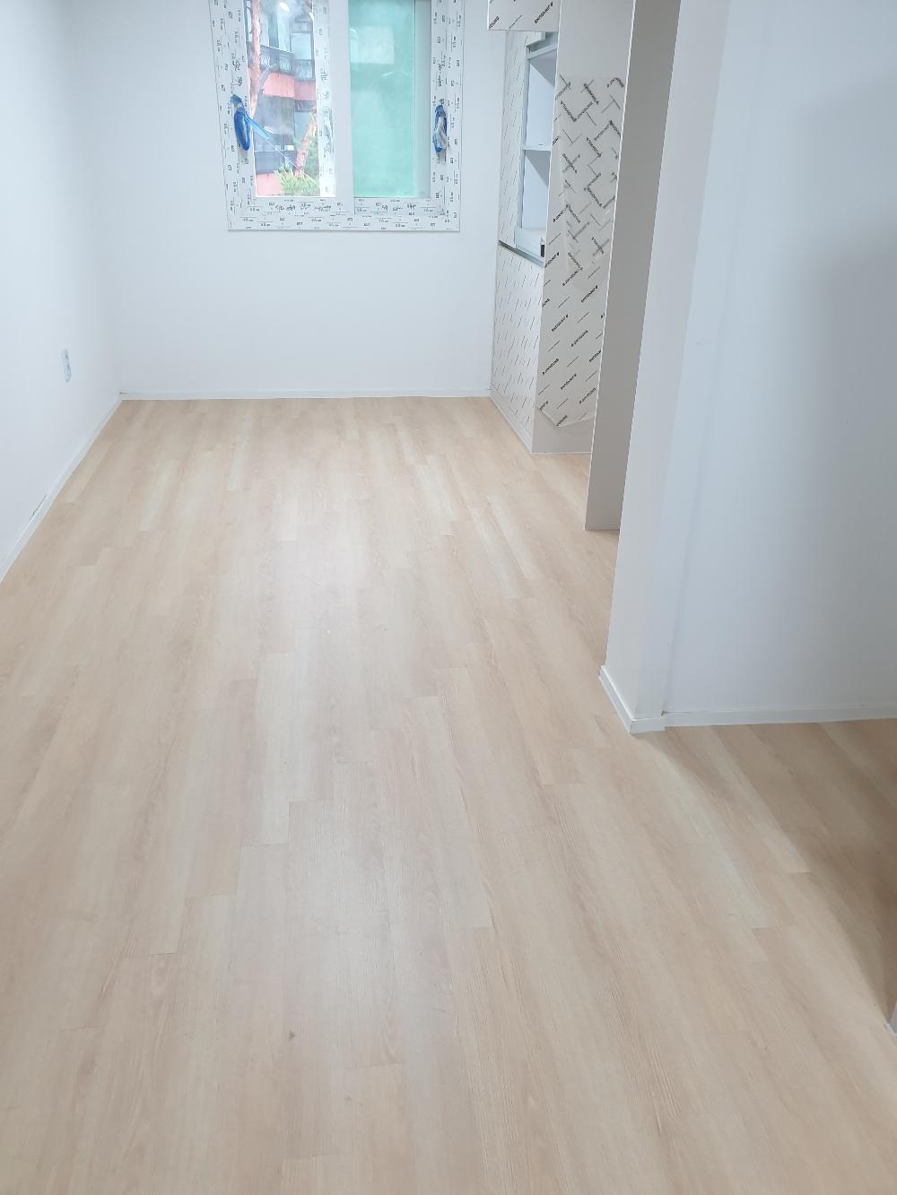 흰 벽과 목재 바닥이 깔린 텅 빈 실내