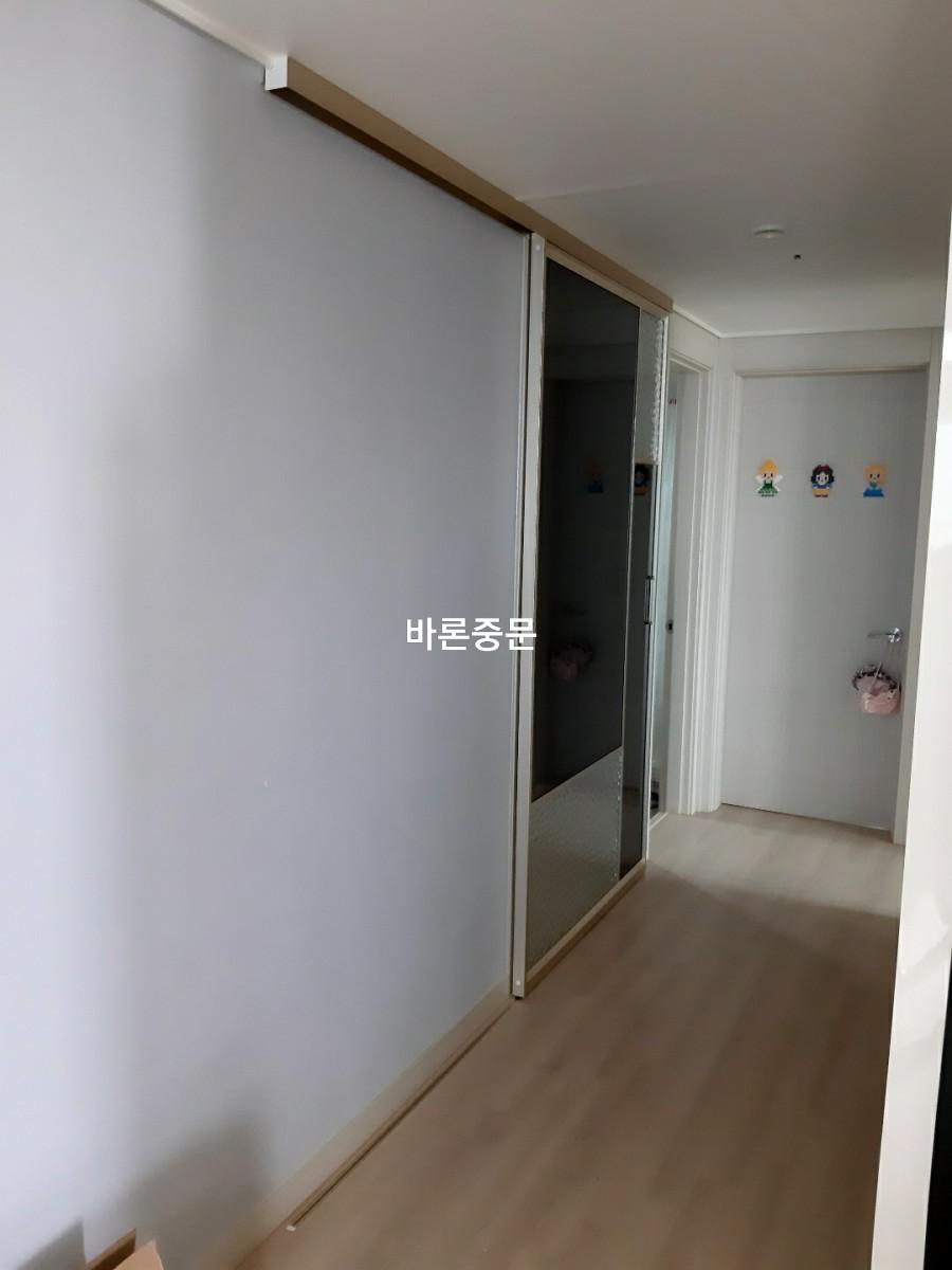 베이지색 마루 위에 설치 중인 슬라이딩 도어