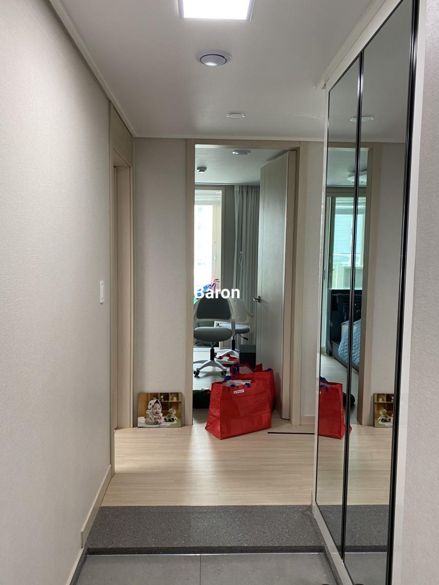 베이지색 벽지와 나무 마루가 깔린 복도 시공 전 모습