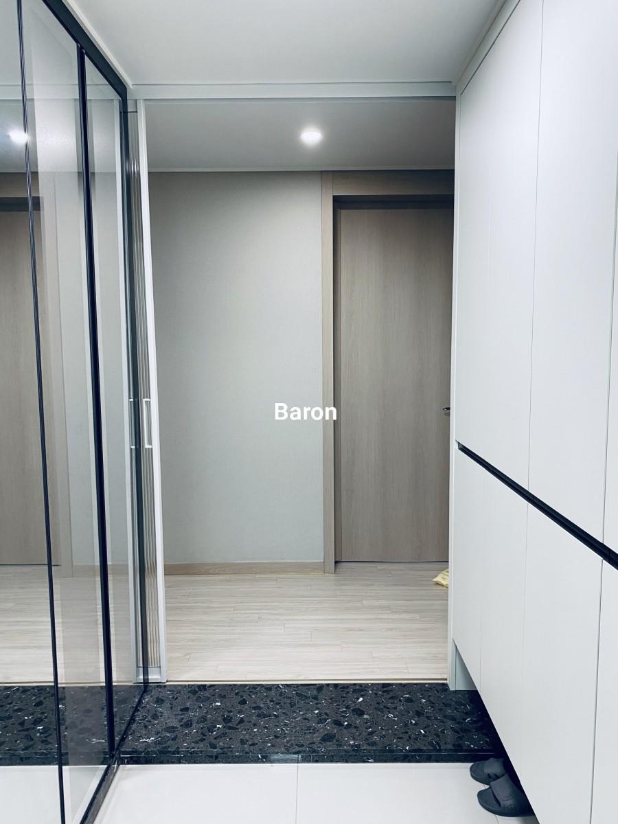 천장 조명 아래로 배치된 중문과 수납장의 시공 모습