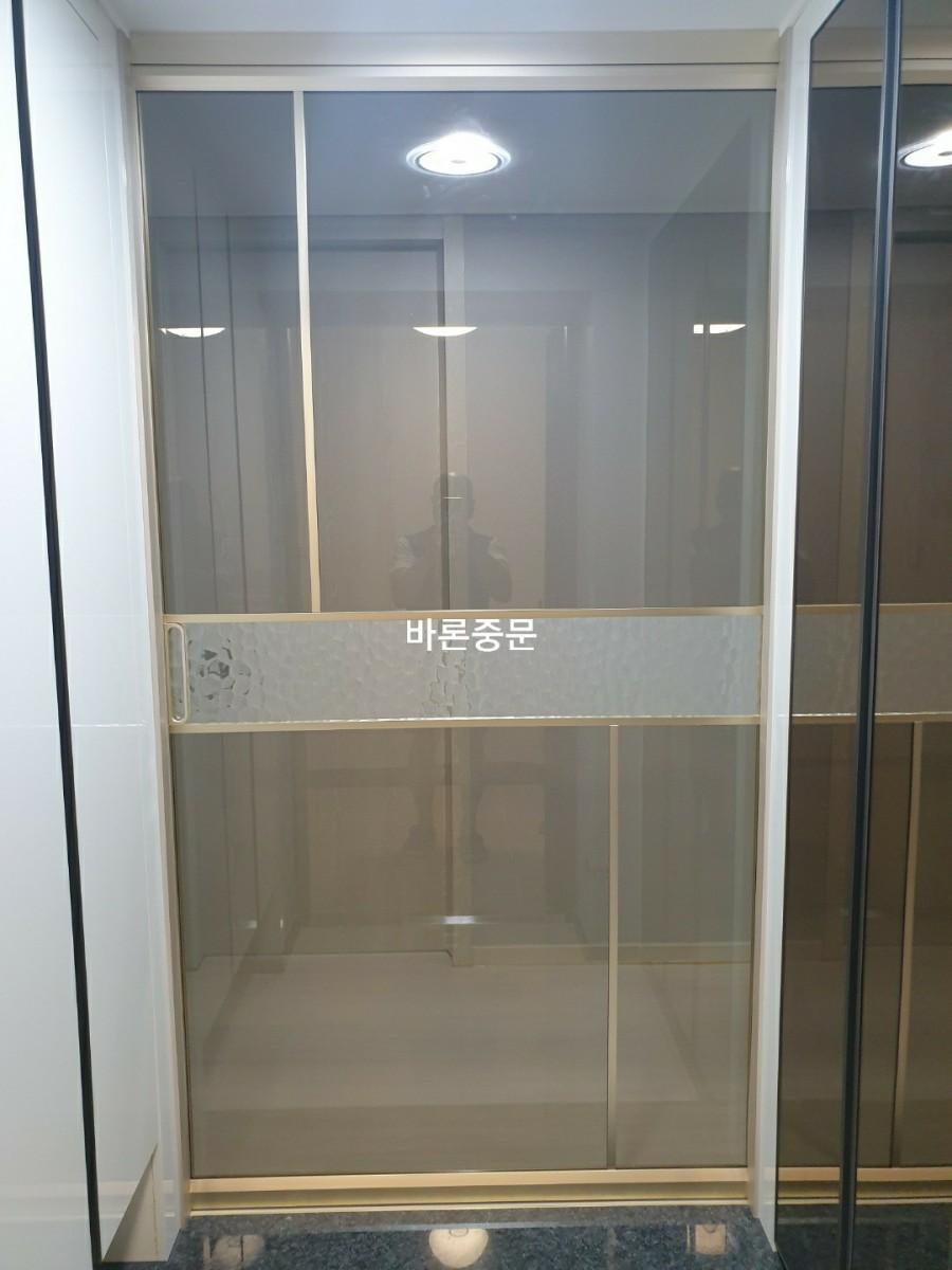 금색 장식과 유리 패널이 결합된 도어 모습