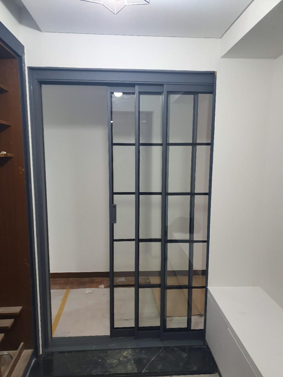 격자 유리 패널과 검은색 프레임이 설치된 실내 공간