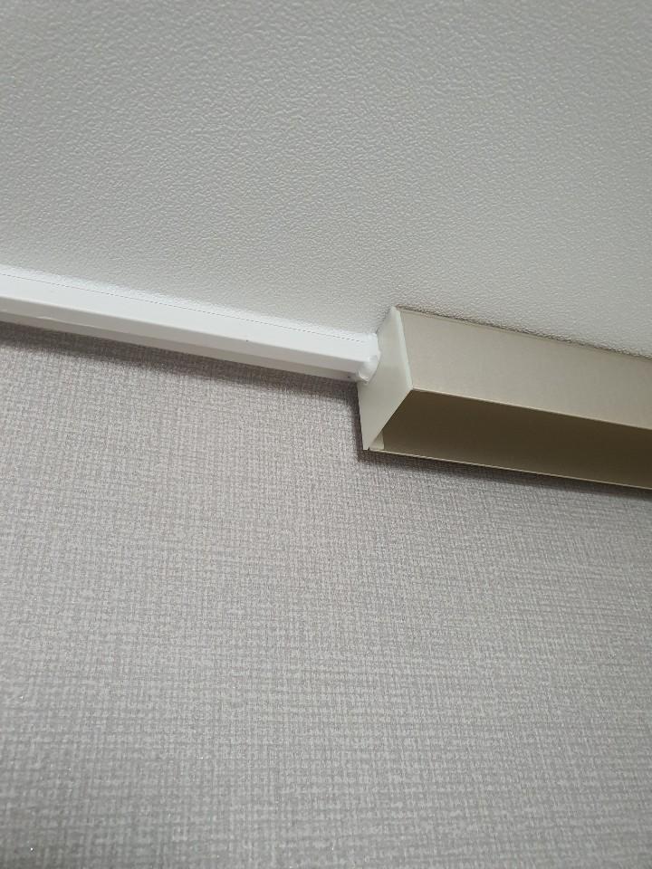 흰색 벽지와 베이지색 바닥재의 경계선