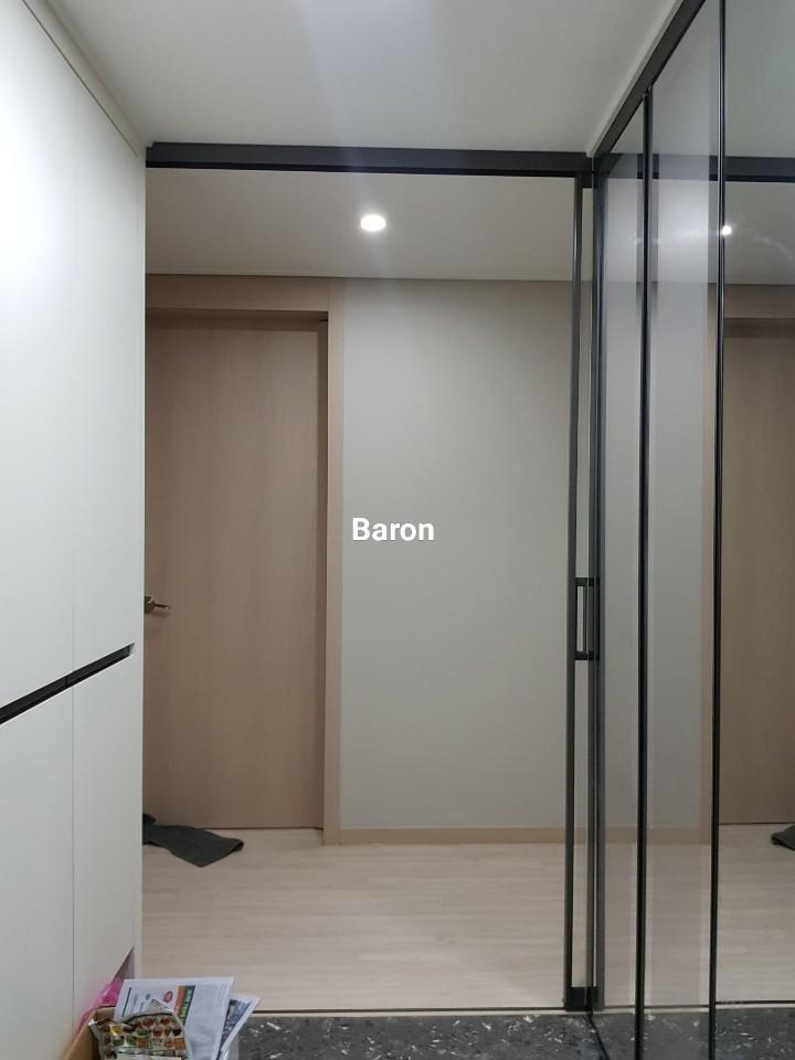 베이지색 벽면과 목재 바닥 사이에 배치된 유리 도어