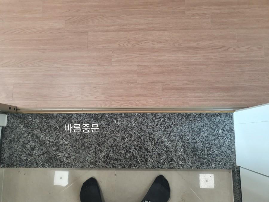 목재 마루와 석재 마감이 만나는 바닥 지점