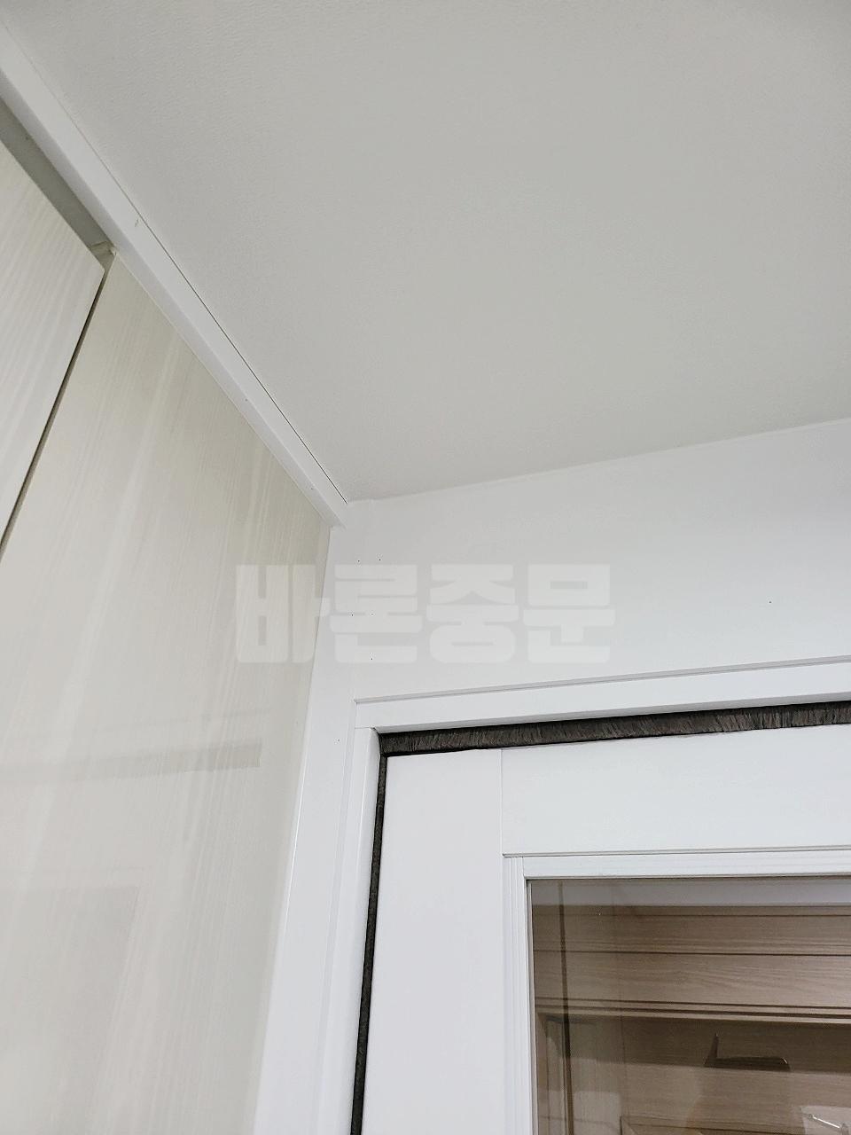 천정과 벽면 화이트 톤에 맞춰 설치 중인 도어 프레임