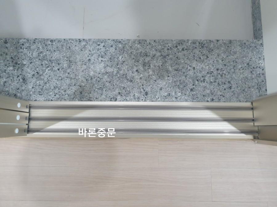 바닥 레일과 벽면 석재 마감의 접합부