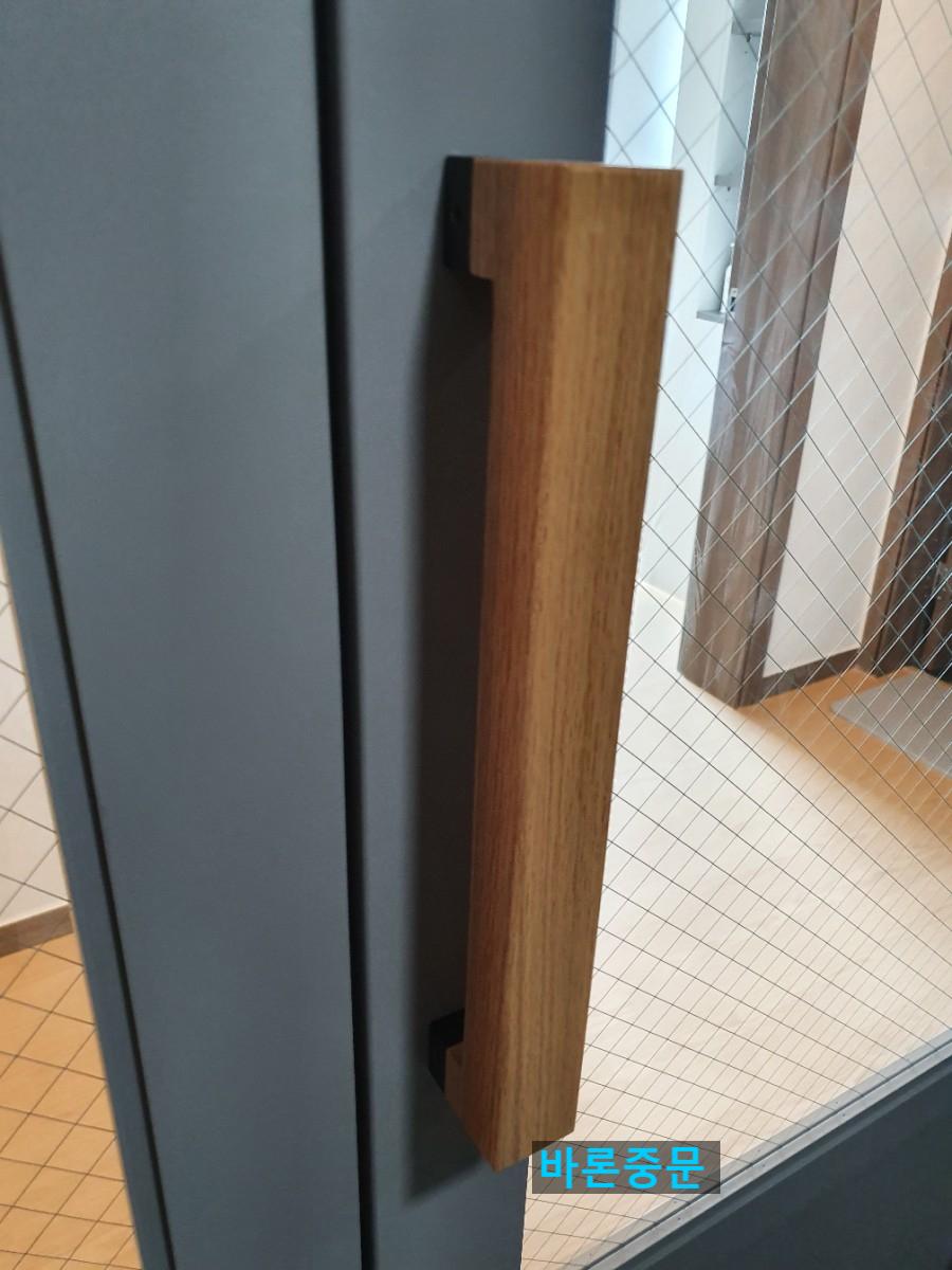 도어에 부착된 나무 재질의 긴 손잡이