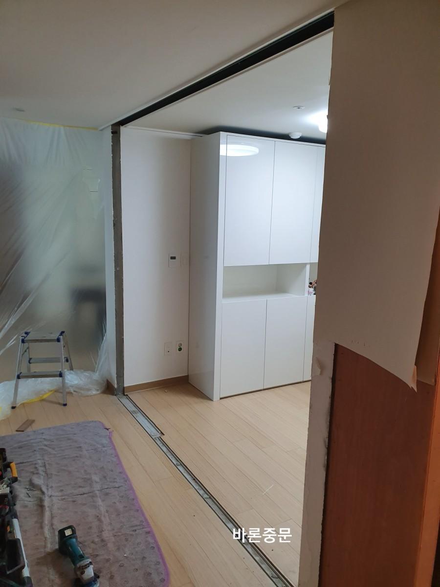 마루 보양 후 중문 철거가 진행 중인 실내 공간