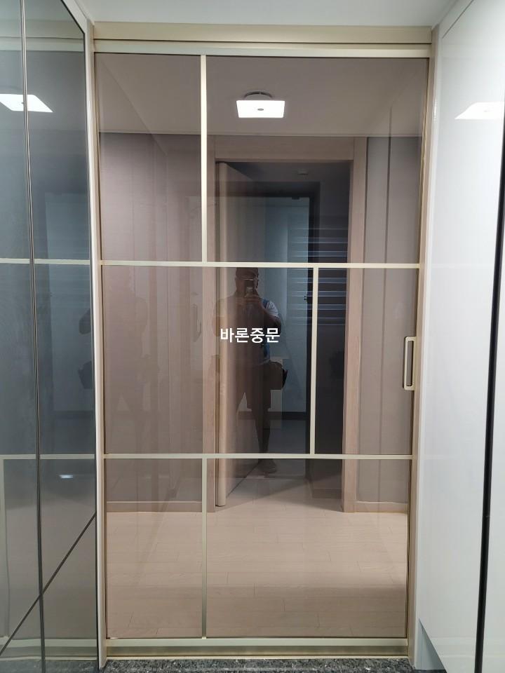 프레임과 유리 패널이 맞물린 도어의 세부 마감