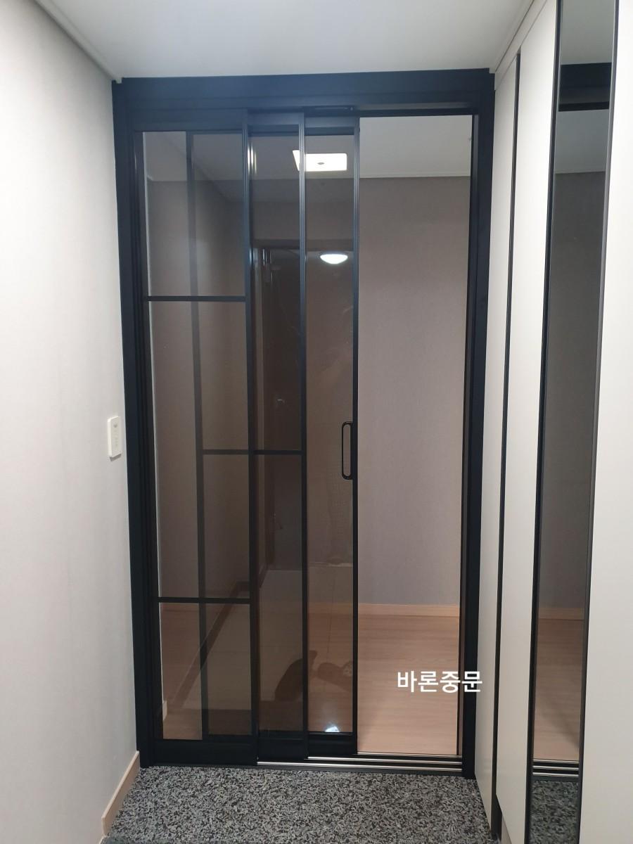 복도 쪽에서 본 블랙 프레임의 슬라이딩 도어