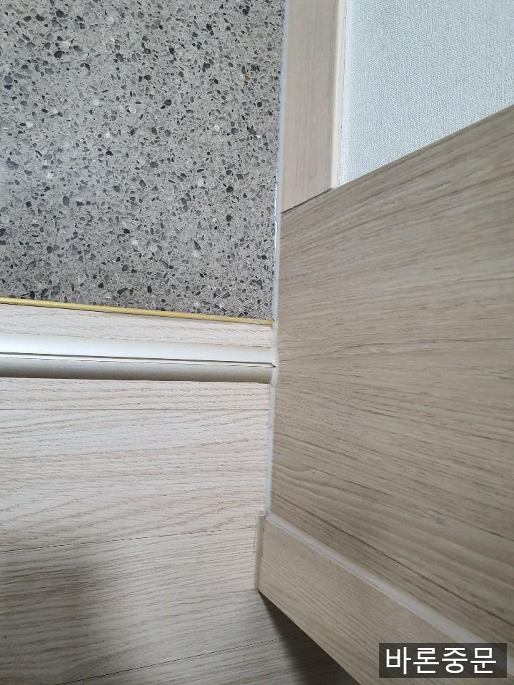 벽면 석재 마감과 도어 프레임의 접합부
