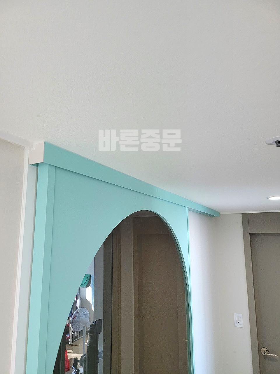 민트색 아치형 프레임으로 화사해진 현관 입구
