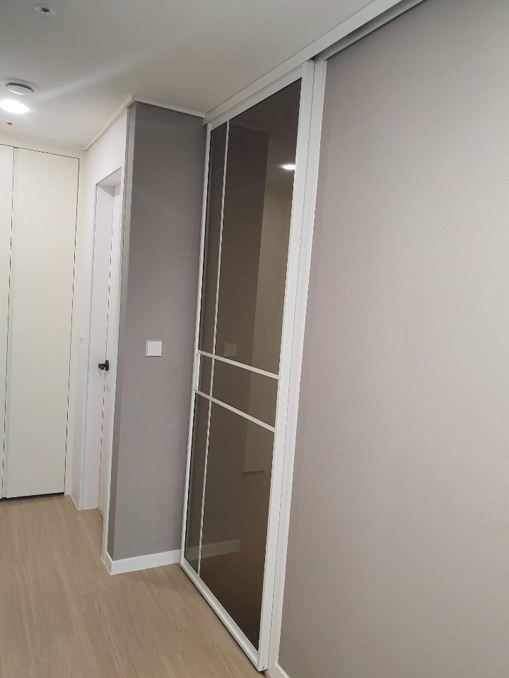 회색 벽면과 대비되는 화이트 슬라이딩 도어