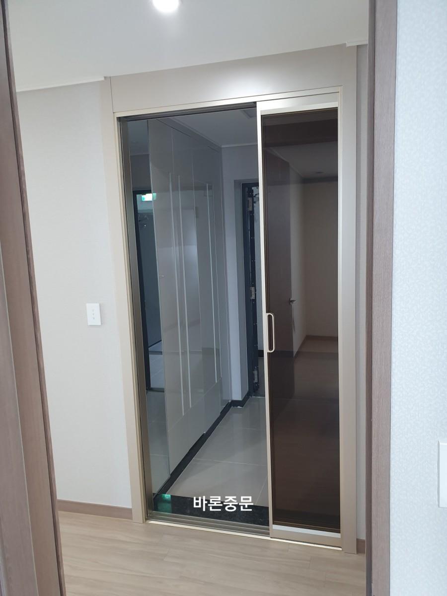 흰색과 베이지색 벽지가 어우러진 중문 설치 공간