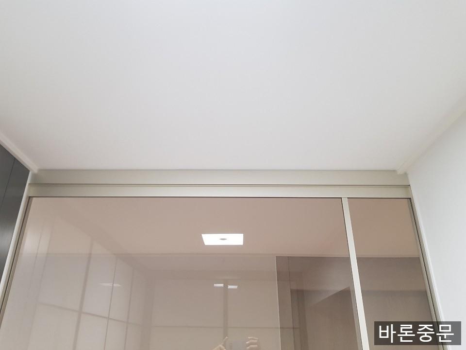 흰색 천장과 유리문 상부의 실리콘 마감 상태