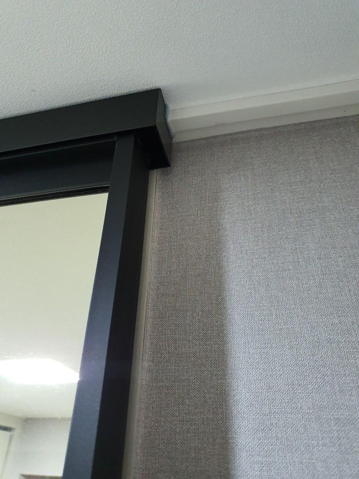회색 벽지와 블랙 프레임 상단의 접합부