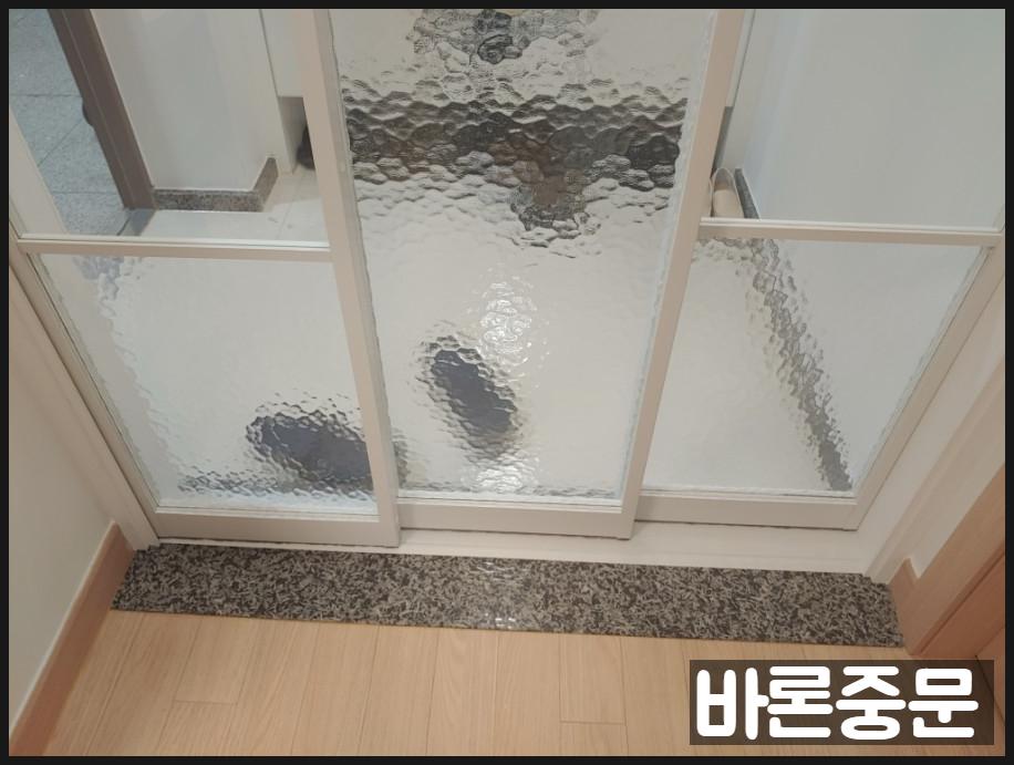 베이지색 마루 바닥과 화이트 중문이 보이는 모습
