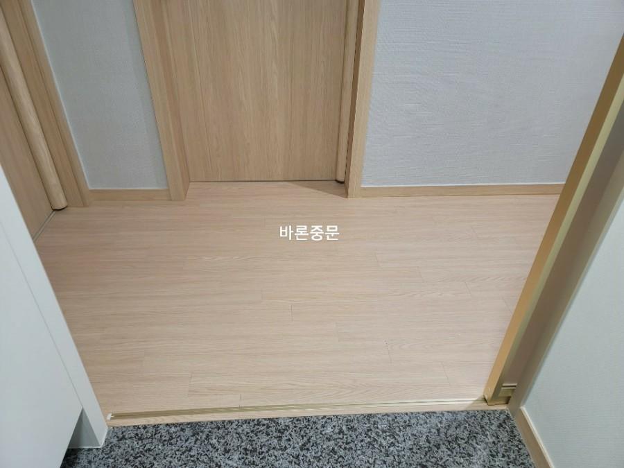 베이지톤 벽지와 마루가 어우러진 복도