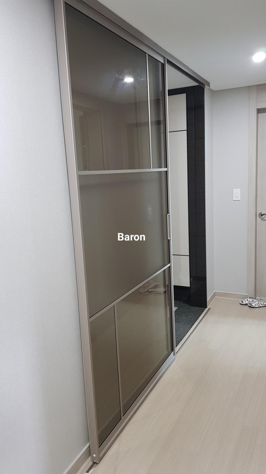 베이지색 목재 마루 위 설치된 반투명 유리 슬라이딩 도어