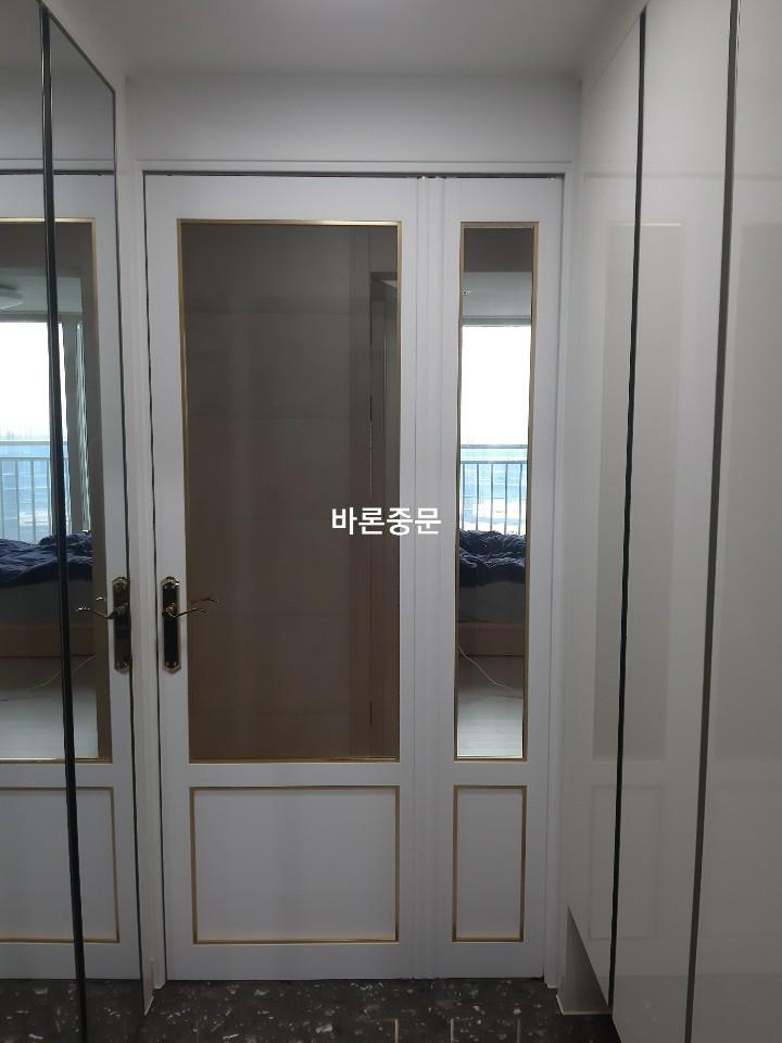 골드 손잡이와 장식선이 적용된 화이트 도어