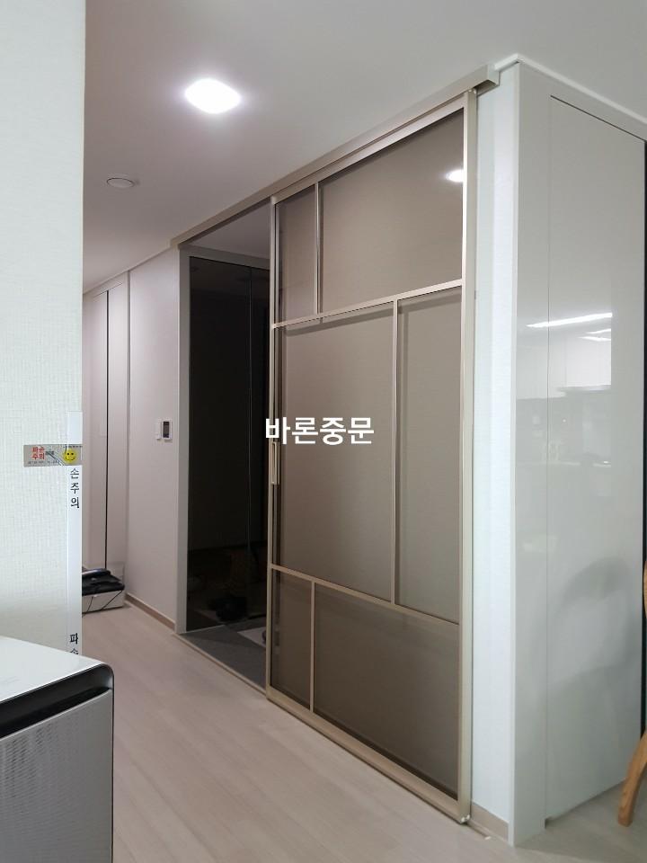 LED 조명 아래로 고정된 현관 중문의 상부 모습