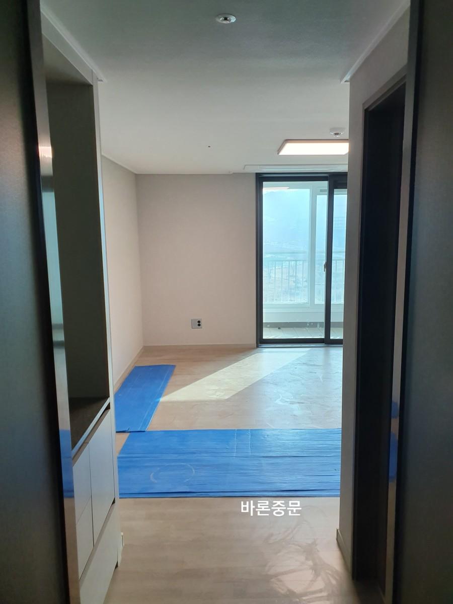 베이지색 벽면과 목재 마루가 보이는 실내 공간