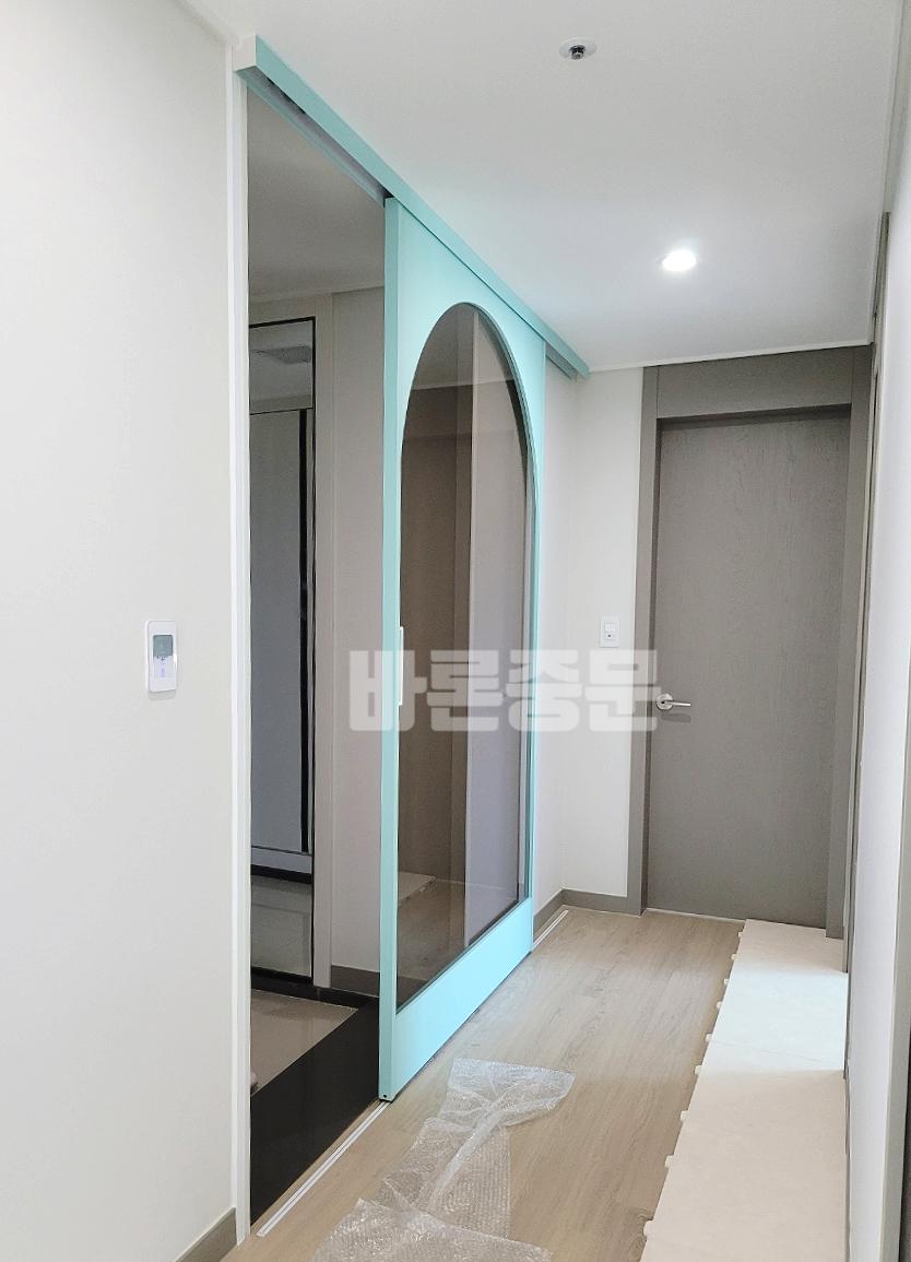 파란색 프레임의 슬라이딩 도어가 설치 중인 모습