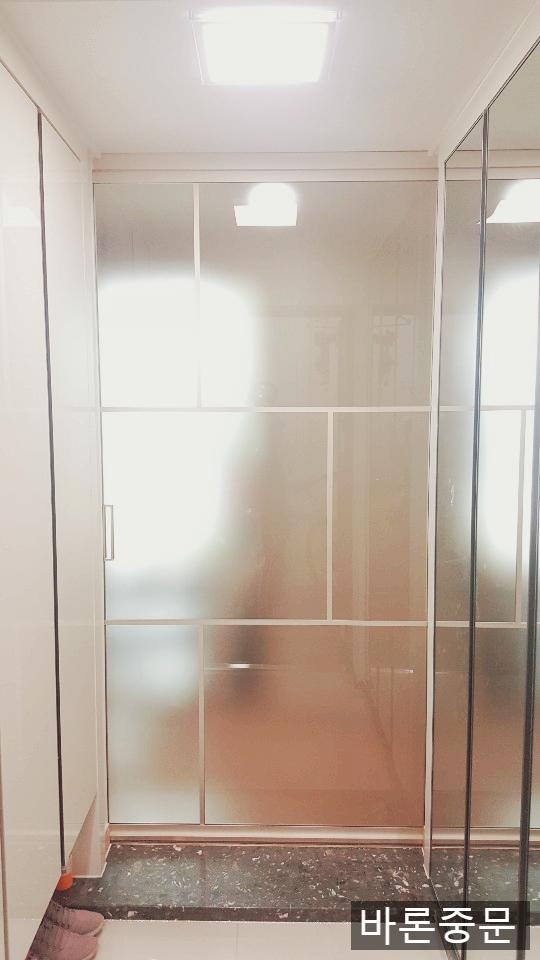 검은색 타일 바닥과 흰색 벽면이 대비되는 복도 전경
