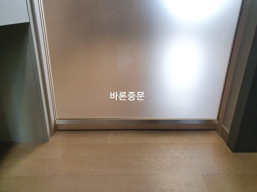 반투명 도어 하단과 목재 바닥의 접합 모습