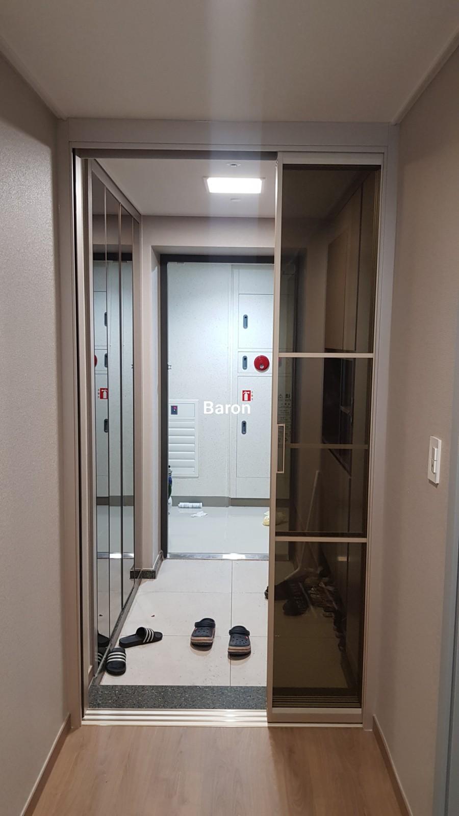 베이지색 벽면과 프레임이 맞닿은 현관 입구
