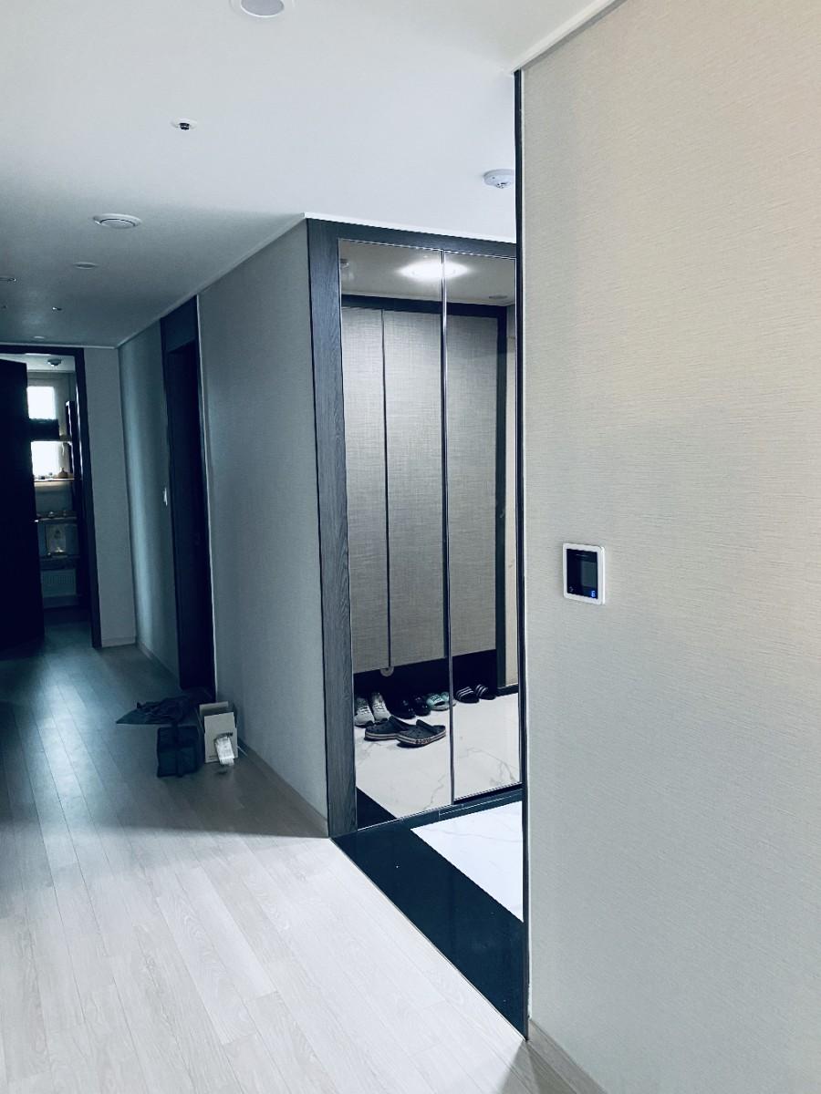 베이지색 벽지와 목재 마루가 깔린 시공 전 복도