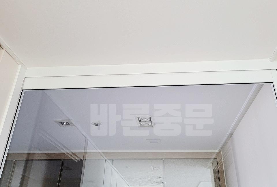 흰 벽과 천정 배경의 투명 유리 문 실내 전경