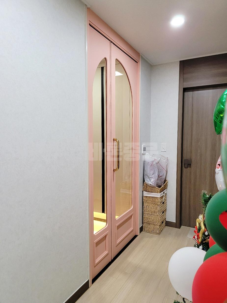 베이지색 마루 위로 설치된 아치형 유리 도어
