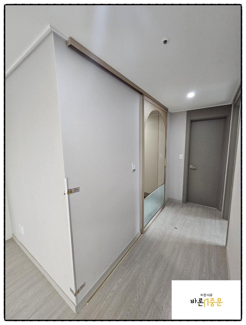 흰 벽과 회색 마루가 어우러진 슬라이딩 도어 공간