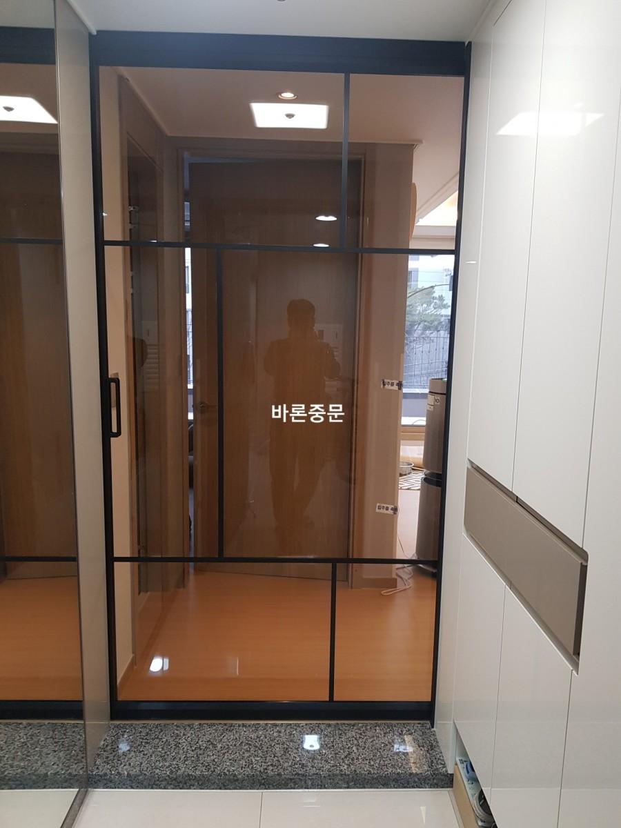 그레이 타일 바닥과 화이트 수납장이 배치된 현관