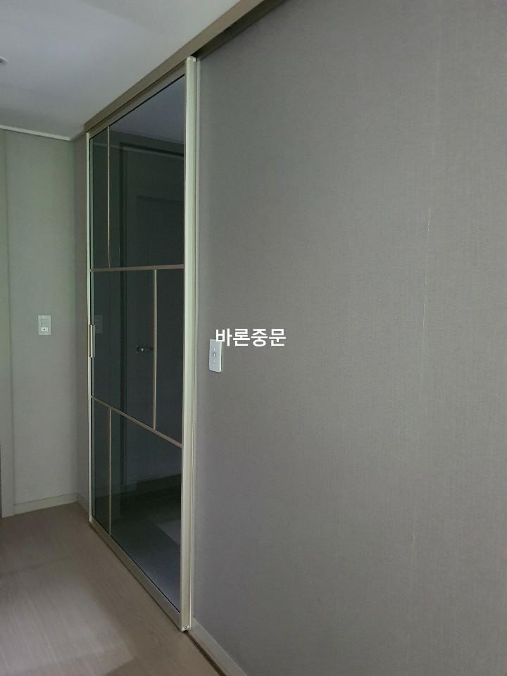회색 벽지와 목재 마루가 어우러진 복도 쪽 중문 모습
