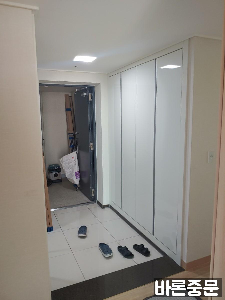 샴페인 골드 중문이 설치된 화이트 톤 현관