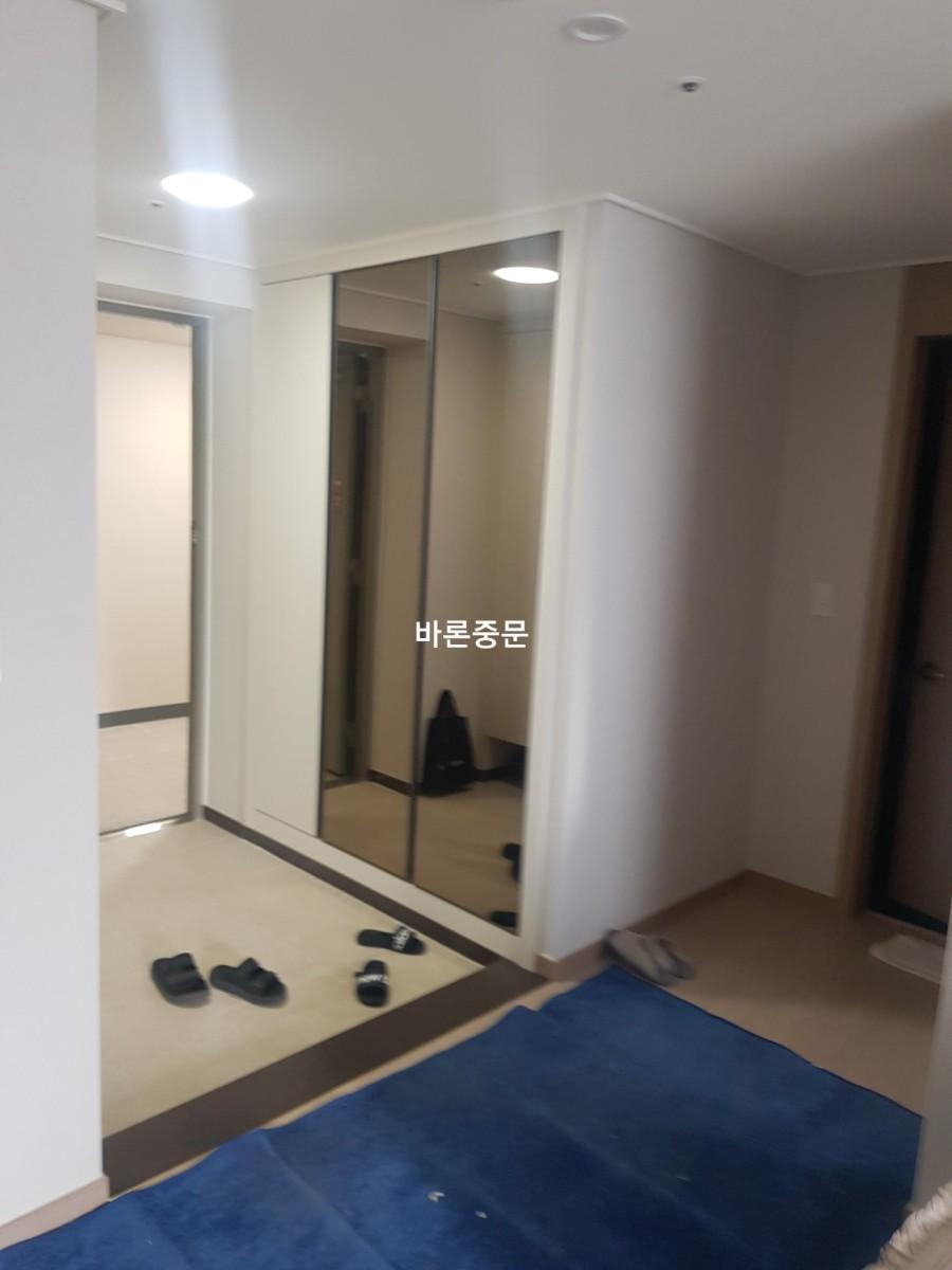 베이지색 바닥재가 깔린 현관 내부의 시공 전 상태