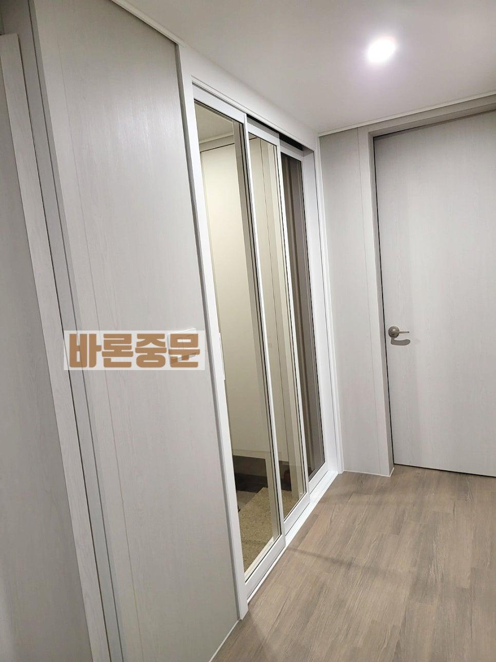 목재 마루 위로 설치된 흰색 슬라이딩 도어