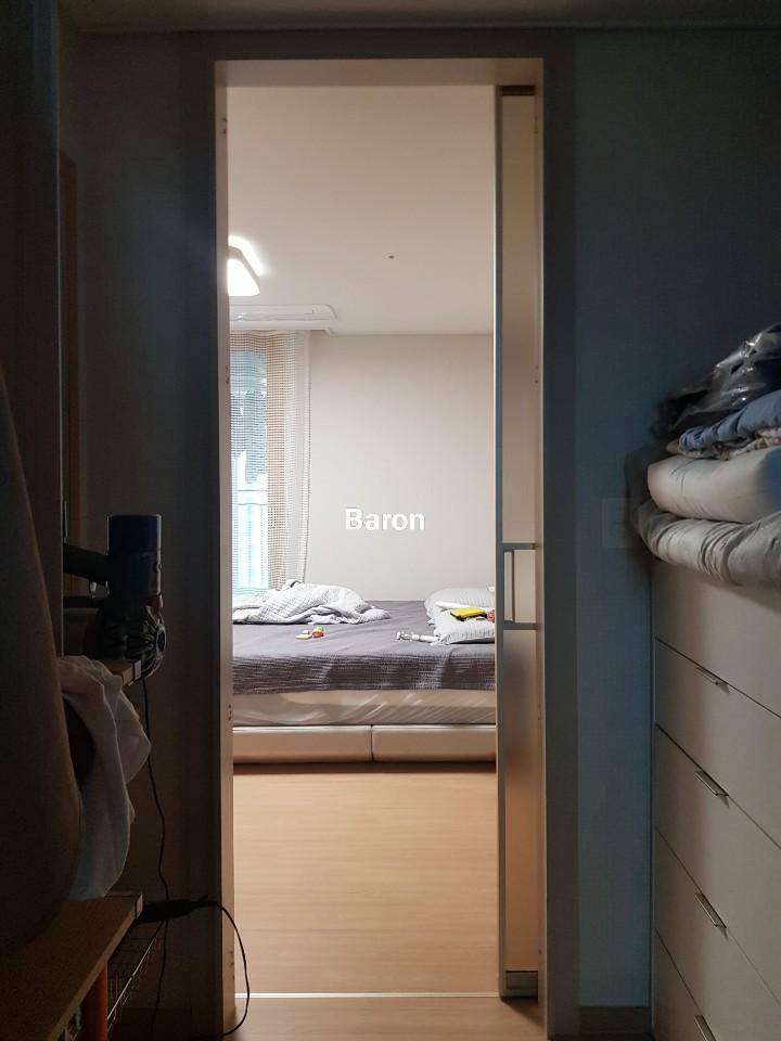 침대와 이불이 놓인 방 안쪽 모습과 도어 프레임