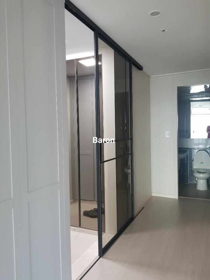 벽 수납장과 매립등이 확인되는 복도 측면 시야